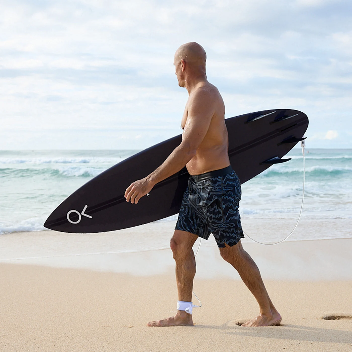 Kelly Slater na praia com uma prancha Firewire
